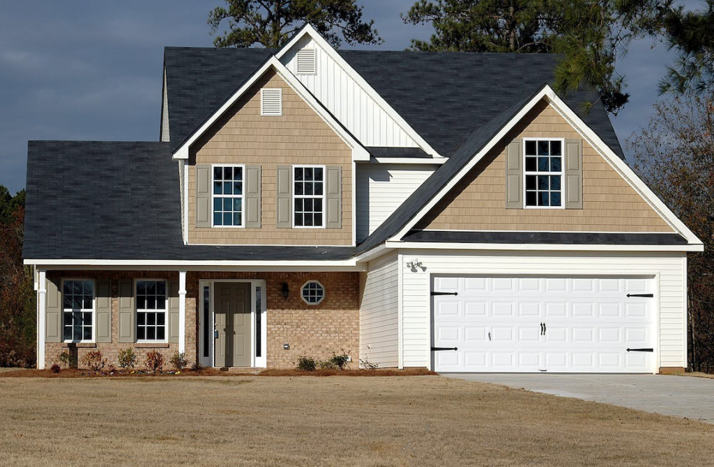 An image of a house with a garage door painted white