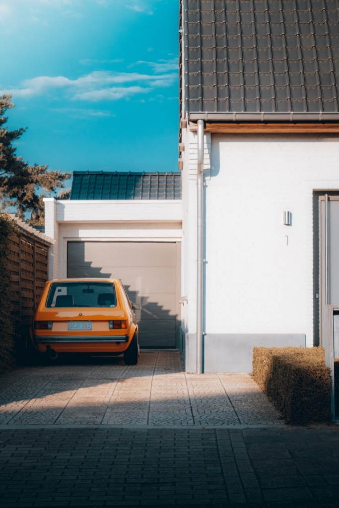 An image showing a car parked outside a garage