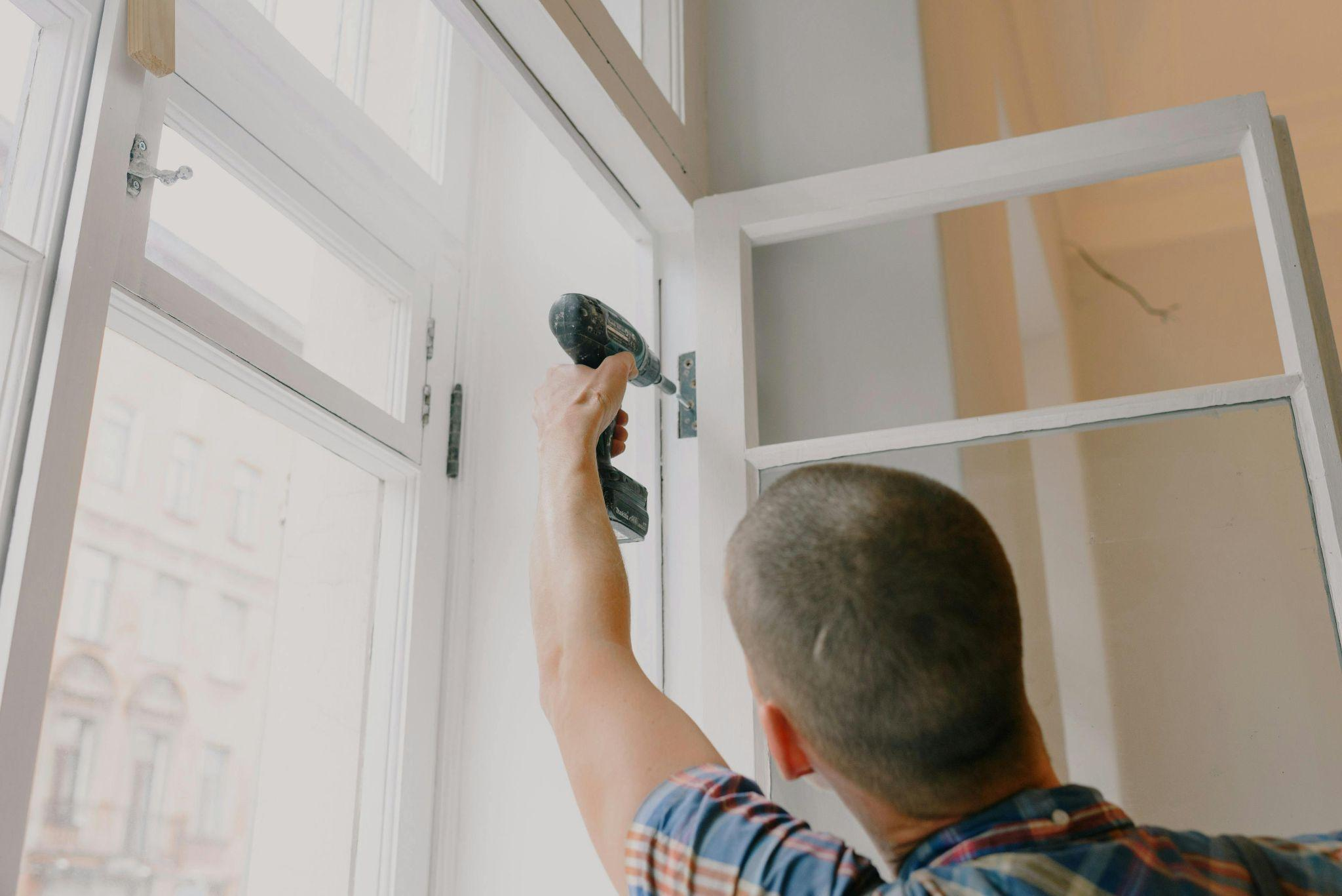 Person using a drill to install windows