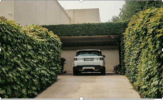 A car on a driveway leading to a garage