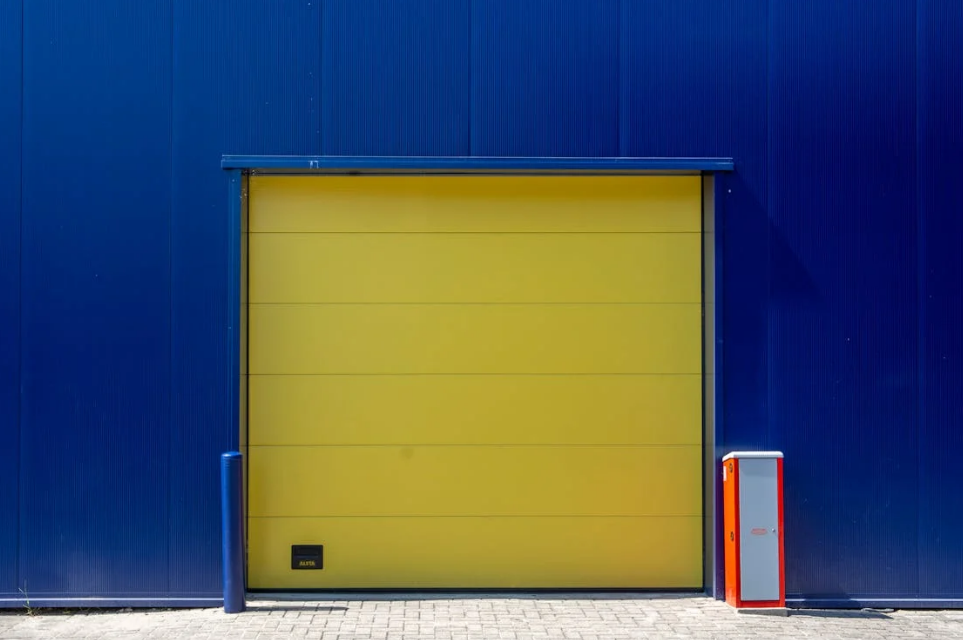 a dark blue wall with a yellow colored garage door